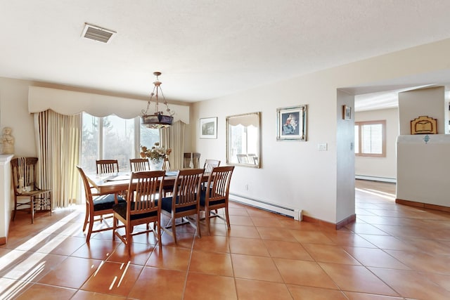 dining room featuring tile patterned flooring and a baseboard heating unit