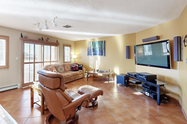 tiled living room with a baseboard heating unit, track lighting, and a textured ceiling