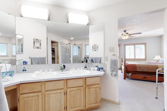 bathroom with tasteful backsplash, vanity, a shower with shower door, and a textured ceiling