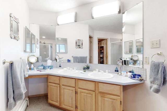 bathroom with vanity, tasteful backsplash, a shower with door, and baseboard heating