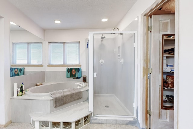 bathroom featuring shower with separate bathtub and a textured ceiling