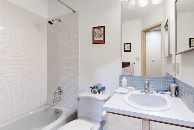 full bathroom with tasteful backsplash, tiled shower / bath, vanity, and toilet