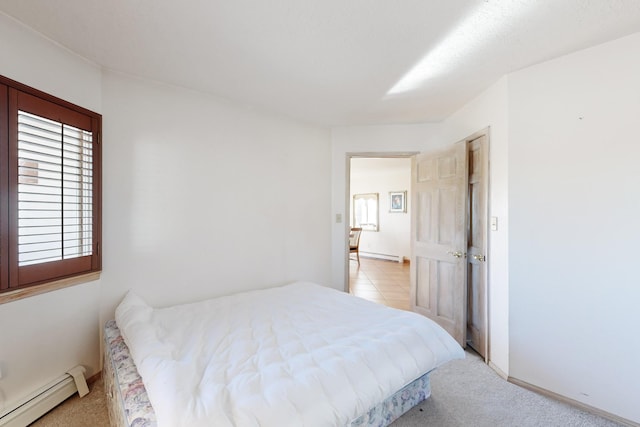 bedroom with light carpet and a baseboard radiator