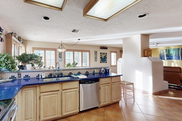 kitchen with stainless steel appliances, light tile patterned flooring, sink, and tasteful backsplash