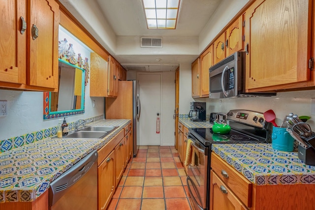 kitchen featuring appliances with stainless steel finishes, sink, and light tile patterned floors