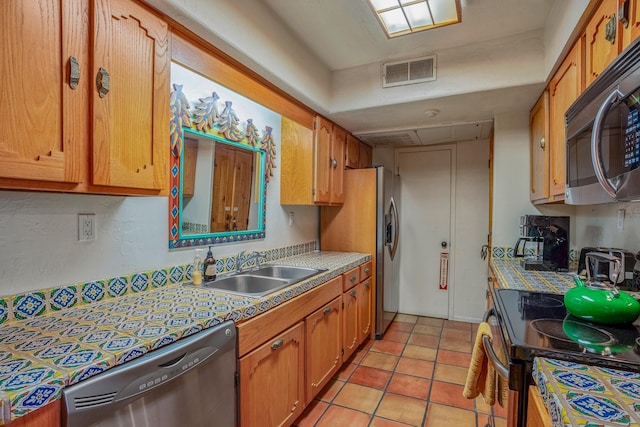 kitchen featuring sink, light tile patterned floors, and black appliances