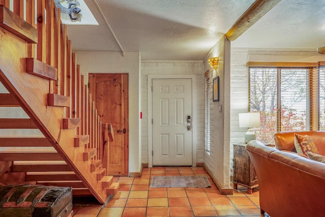 tiled foyer with a textured ceiling