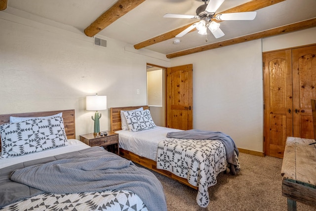 carpeted bedroom with beamed ceiling and ceiling fan