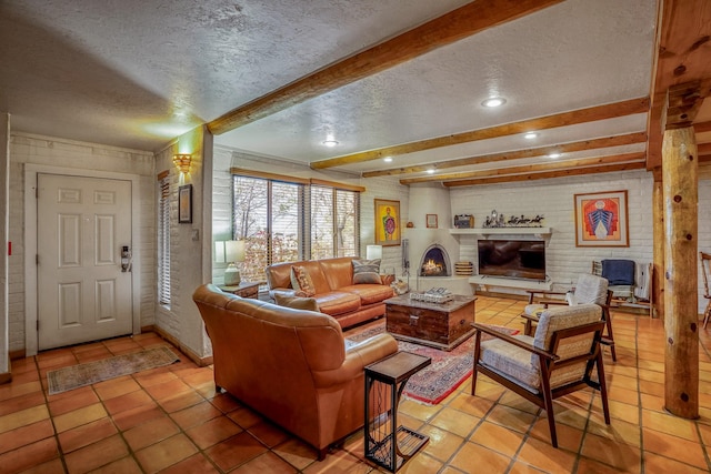 living room featuring beamed ceiling, tile patterned floors, a brick fireplace, and a textured ceiling