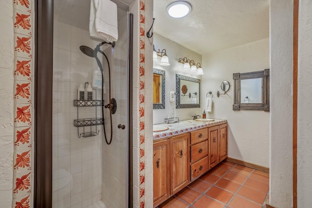 bathroom featuring tile patterned floors, a shower with shower door, a textured ceiling, and vanity