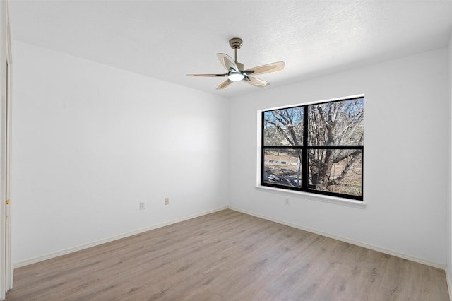 empty room with ceiling fan and light hardwood / wood-style flooring