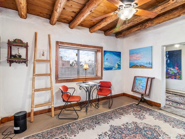 living area with baseboards, ceiling fan, wood ceiling, and beam ceiling