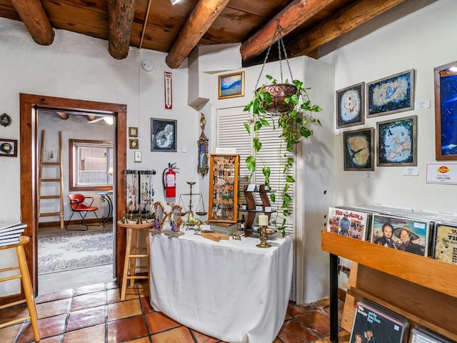 living area featuring tile patterned floors, beamed ceiling, and wooden ceiling