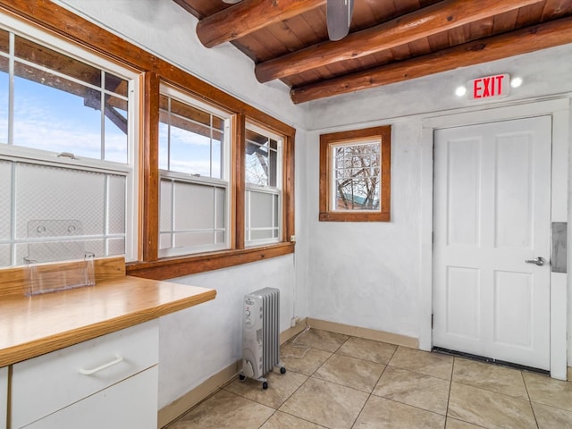 tiled entryway with wood ceiling, a wealth of natural light, radiator, and beamed ceiling