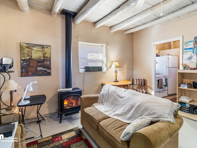 bedroom featuring beamed ceiling, a wood stove, concrete floors, white fridge, and wood ceiling