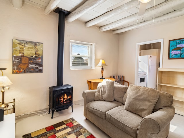 living room featuring beamed ceiling, a wood stove, and wood ceiling