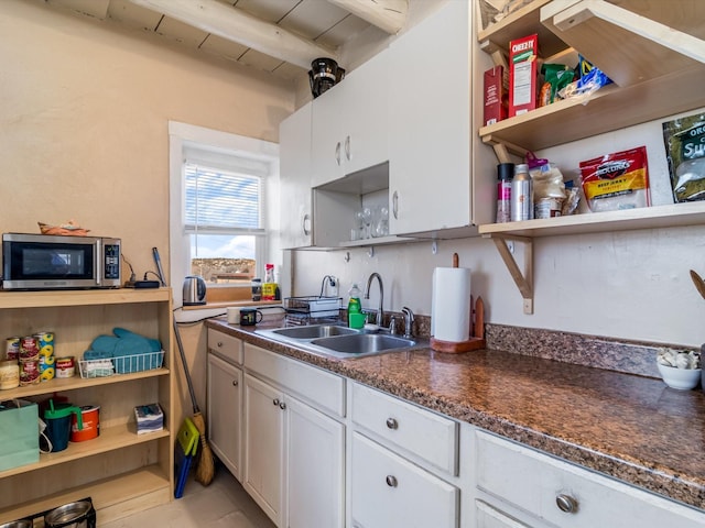 kitchen featuring sink, light tile patterned floors, beam ceiling, white cabinets, and wooden ceiling