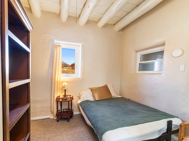 carpeted bedroom featuring a textured wall and beam ceiling