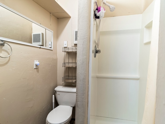 bathroom featuring toilet, a textured wall, and visible vents