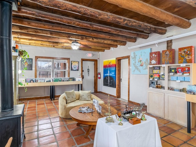 tiled living room featuring wooden ceiling, beamed ceiling, and a wood stove