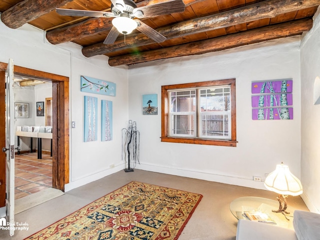 living area featuring a ceiling fan, wooden ceiling, beam ceiling, and baseboards