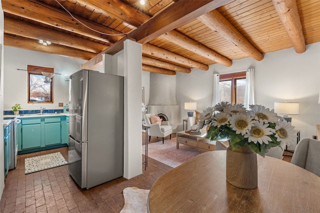 dining space featuring sink, wooden ceiling, and beam ceiling