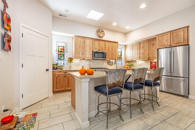 kitchen with sink, tasteful backsplash, stainless steel appliances, beverage cooler, and light stone countertops