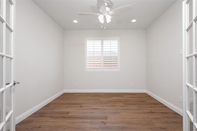 spare room featuring dark hardwood / wood-style flooring, french doors, and ceiling fan