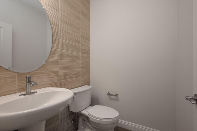 bathroom featuring sink, tile walls, decorative backsplash, and toilet