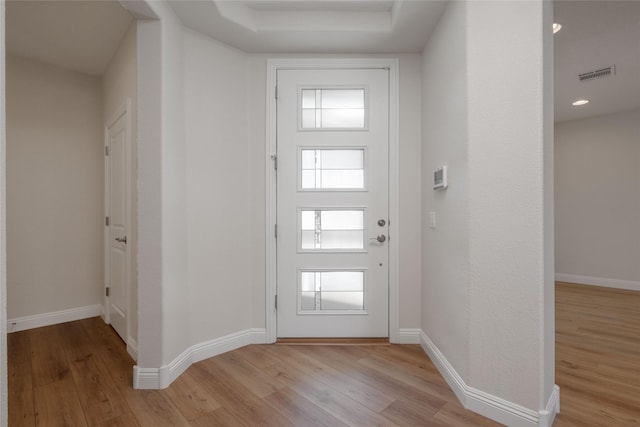 foyer entrance with light hardwood / wood-style floors and a healthy amount of sunlight