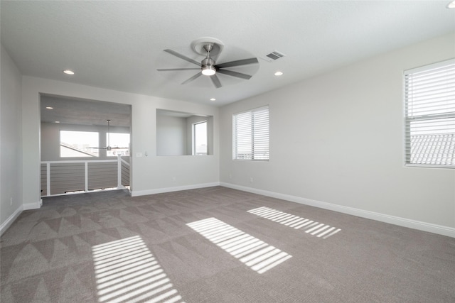 empty room featuring ceiling fan and carpet