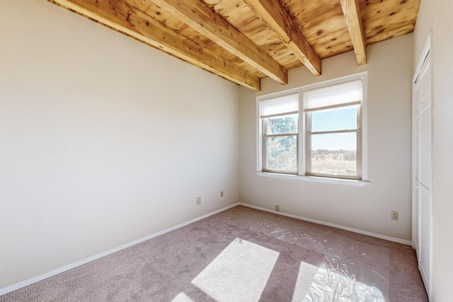 carpeted spare room with wood ceiling and beam ceiling