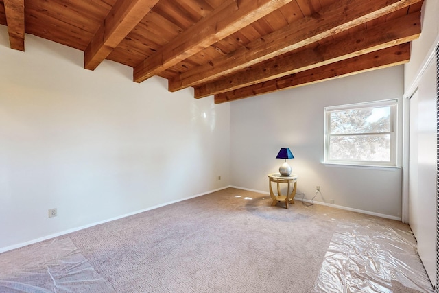 carpeted spare room with beamed ceiling and wooden ceiling