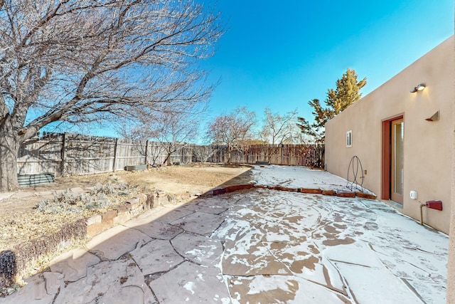 snowy yard with a patio area