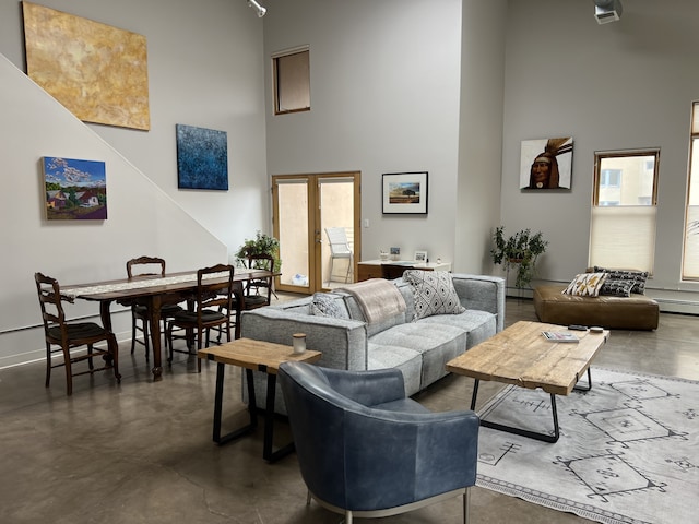 living room featuring a baseboard heating unit and a high ceiling