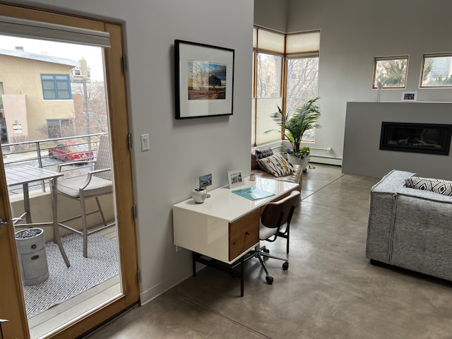 office space featuring baseboard heating and concrete flooring