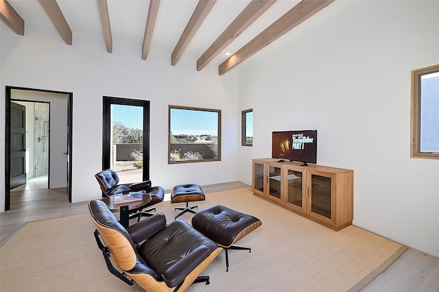 living area with beamed ceiling and light hardwood / wood-style floors