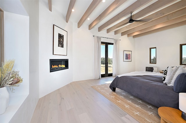 bedroom with beamed ceiling, light wood-type flooring, french doors, and access to outside