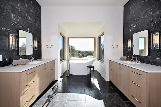 bathroom with vanity, tile walls, and a tub to relax in