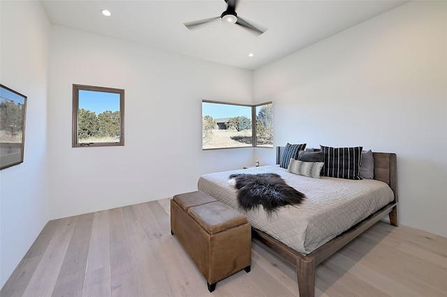 bedroom with ceiling fan, light hardwood / wood-style floors, and multiple windows