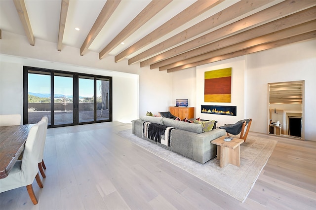 living room with french doors, beam ceiling, and light hardwood / wood-style floors