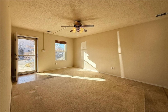 carpeted spare room with ceiling fan and a textured ceiling