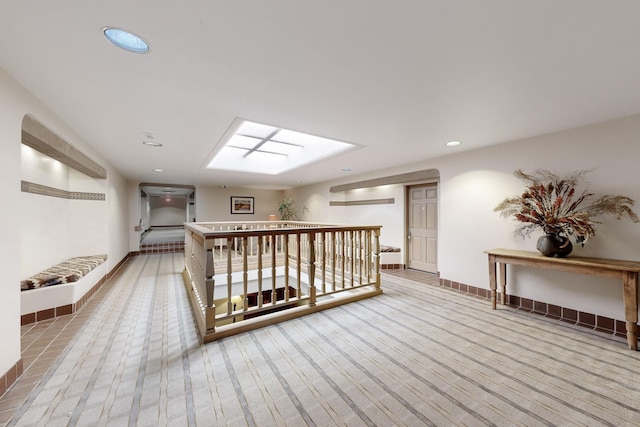 hall featuring light carpet and a skylight