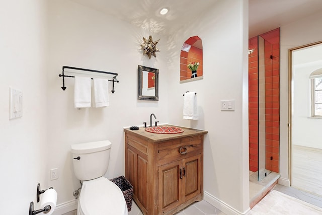 bathroom featuring vanity, tiled shower, and toilet