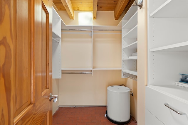 walk in closet featuring beamed ceiling