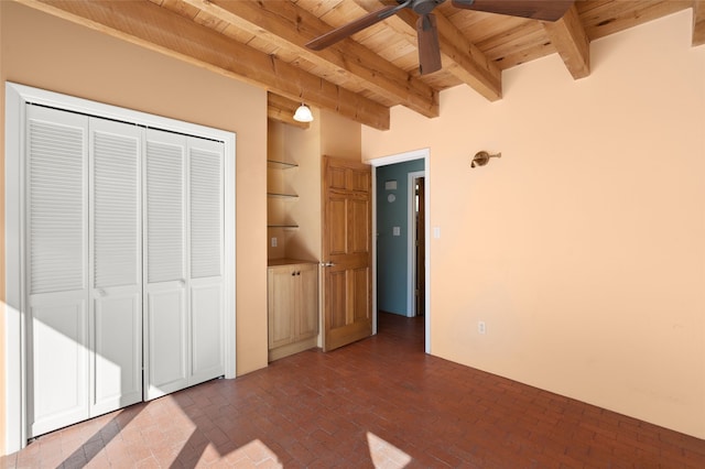 unfurnished bedroom with wood ceiling, beam ceiling, and a closet