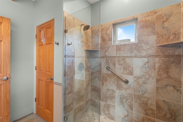 bathroom with a shower with door