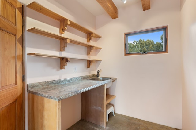 interior space featuring beam ceiling and sink