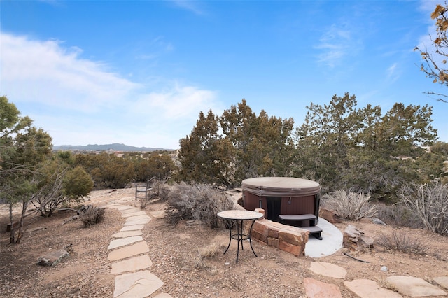 view of yard with a hot tub and a mountain view