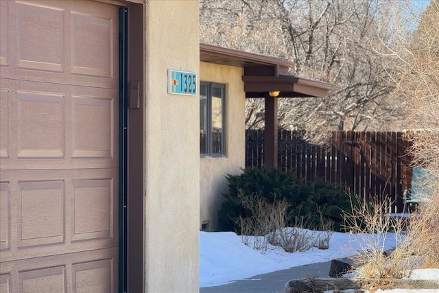 view of snowy exterior featuring a garage